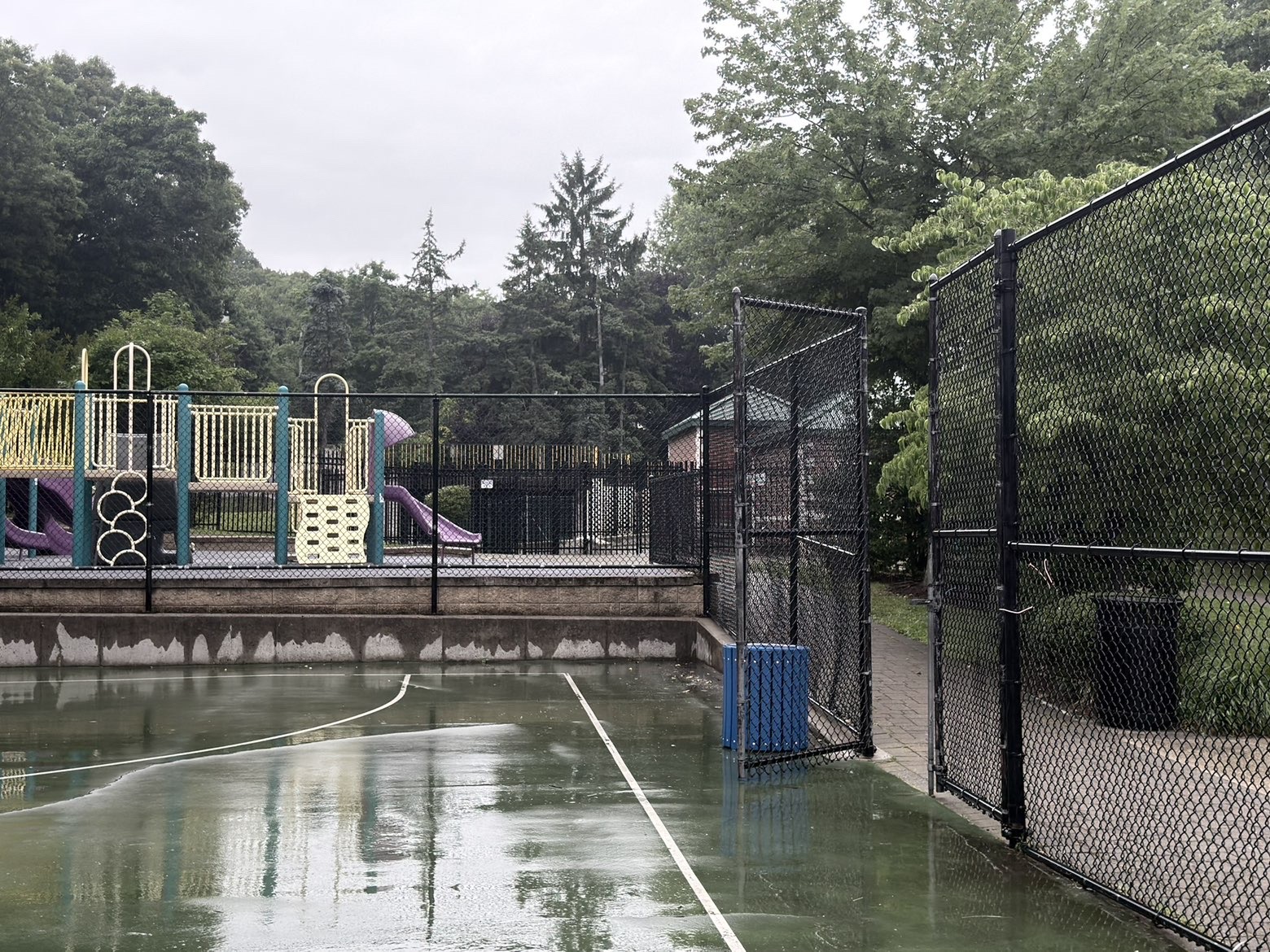 The court entrance and perimeter wall beside a fenced playground