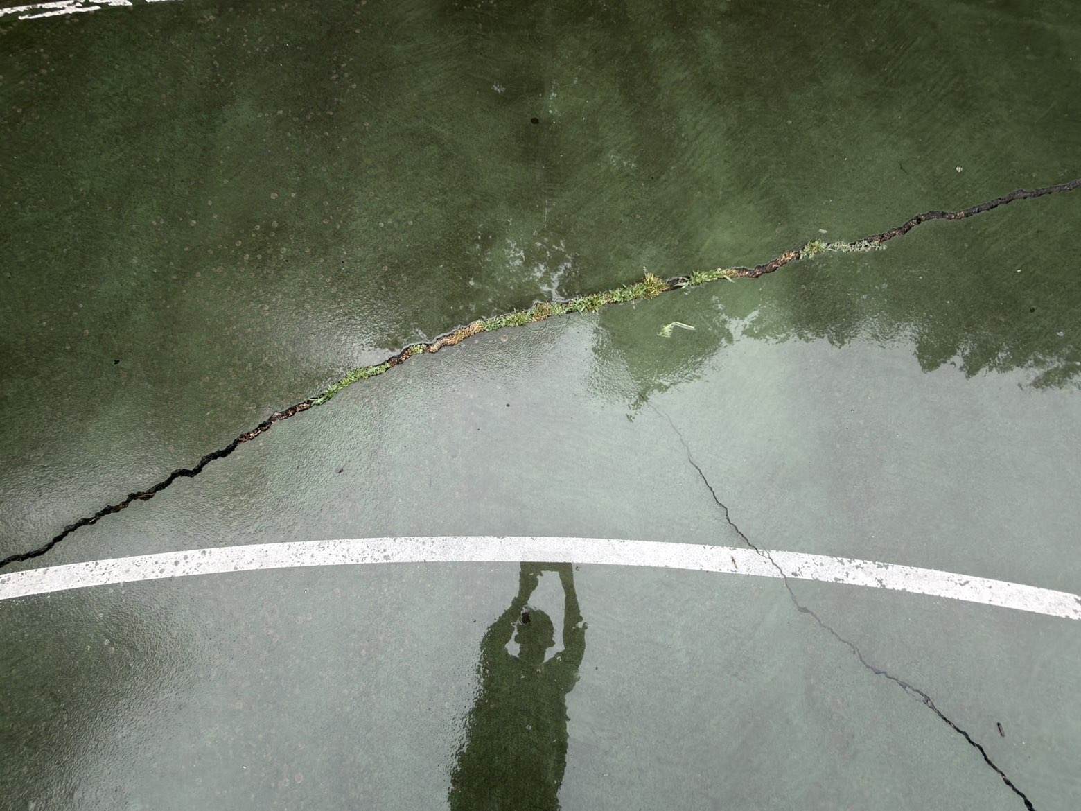 A deep crack in the current green court surface