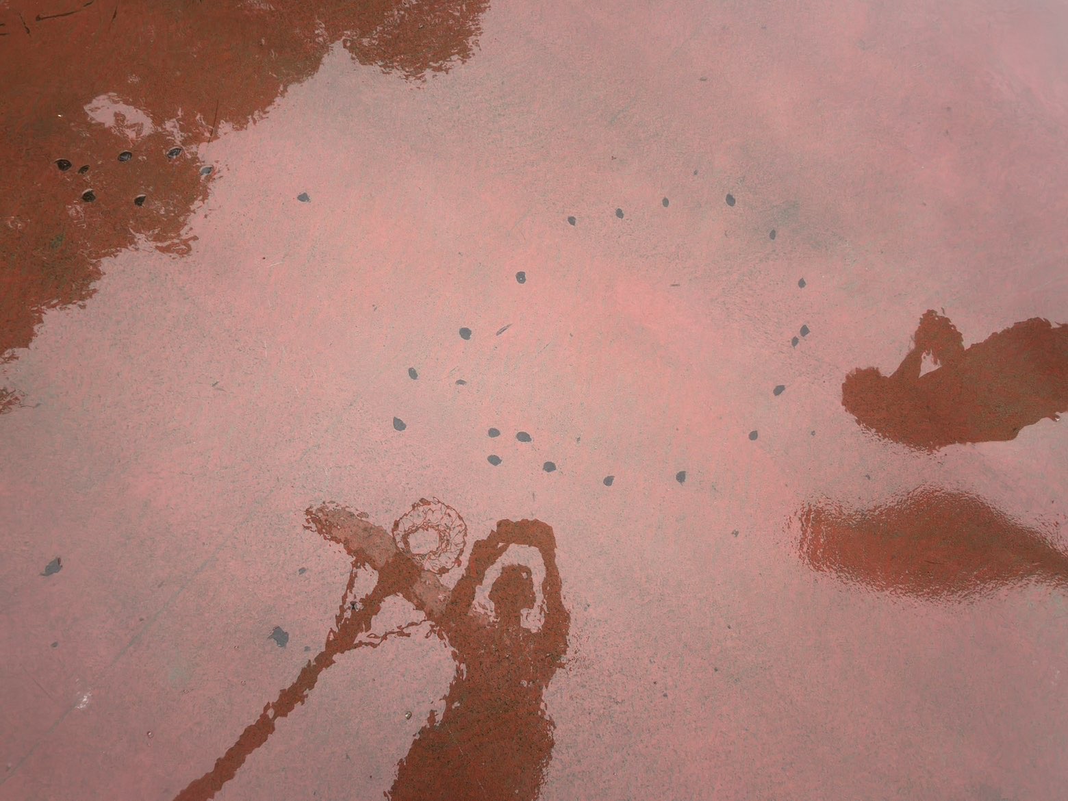 Worn patches in the red-painted key on the current basketball court